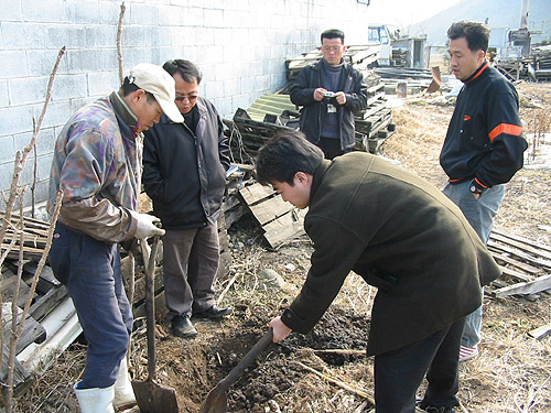 폐유 불법매립장소를 조사하고 있는 군청관계자와 환경연합 김달수씨 